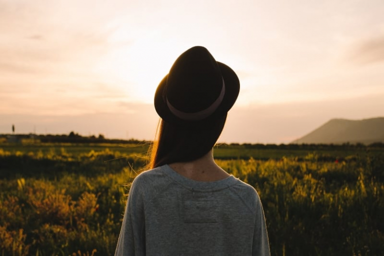 woman with hat looking at field