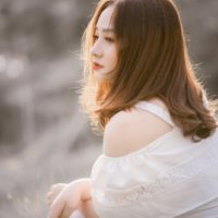 woman in white top sitting outdoor