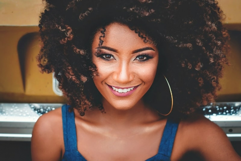 smiling woman in blue top standing outdoor