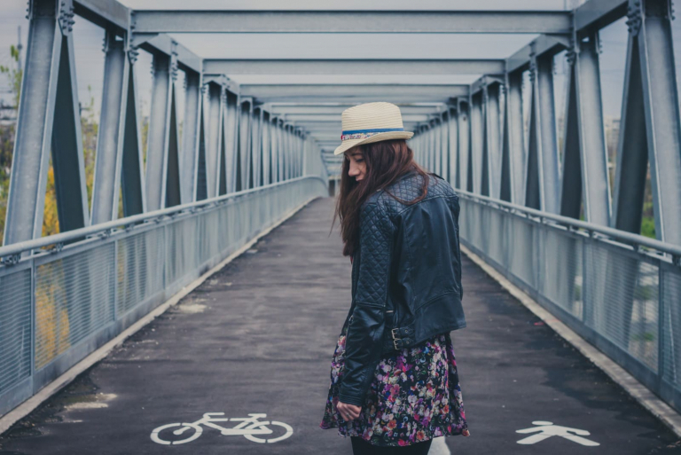 girl walking away on a bridge