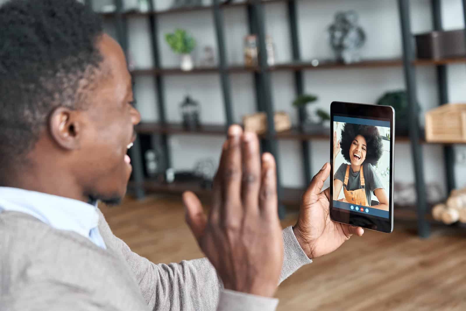 a smiling man on camera talking to a woman with frizzy hair