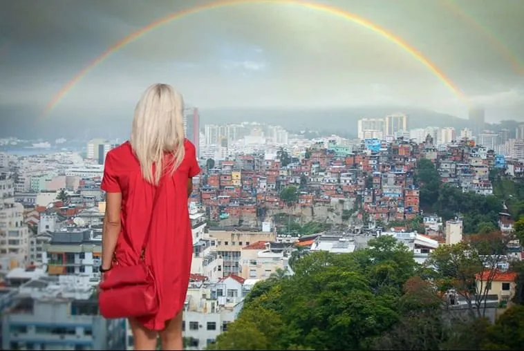 backview of a woman facing a rainbow over the city