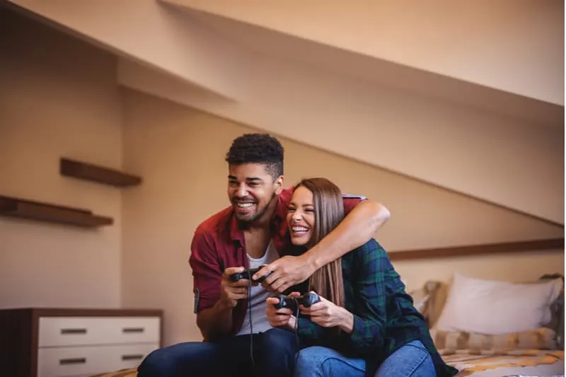 cheerful couple playing video games in the living room