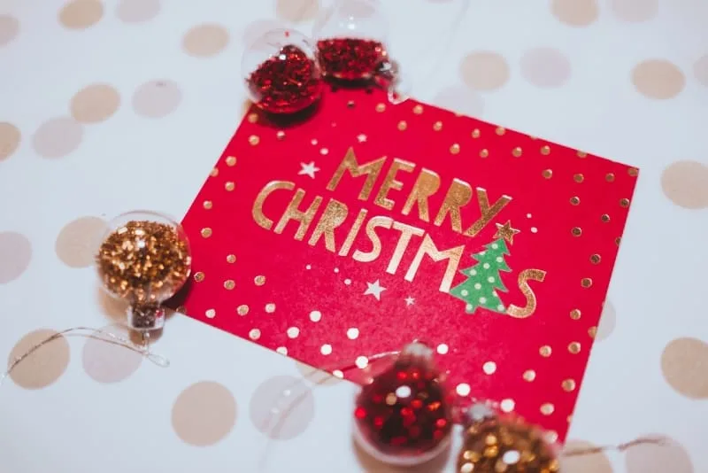 christmas card near red and gold ornaments