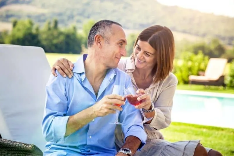 couple celebrating anniversary outdoors clinking wine glasses