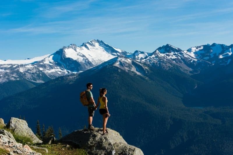 coppia in contatto con la natura in cima alla montagna