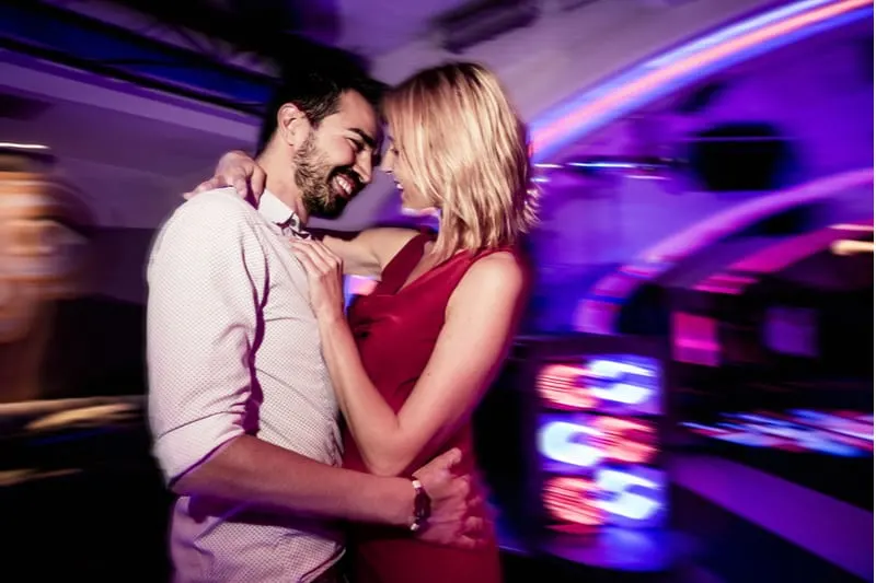 couple dansant dans un pub en mettant l'accent sur le couple et un arrière-plan flou