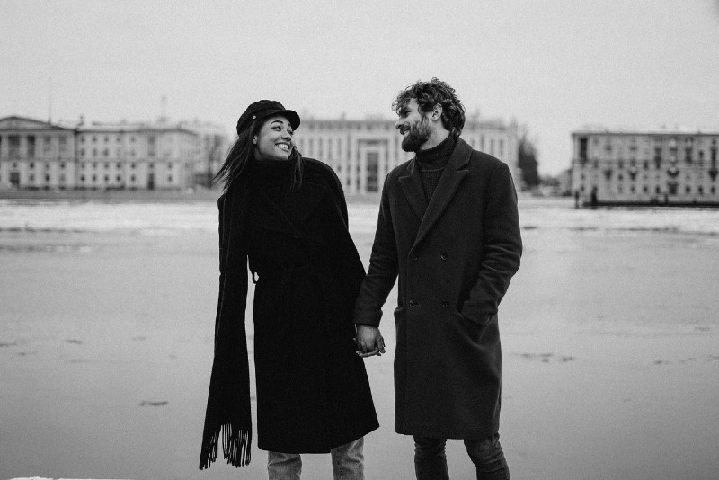 smiling woman and man holding hands near river