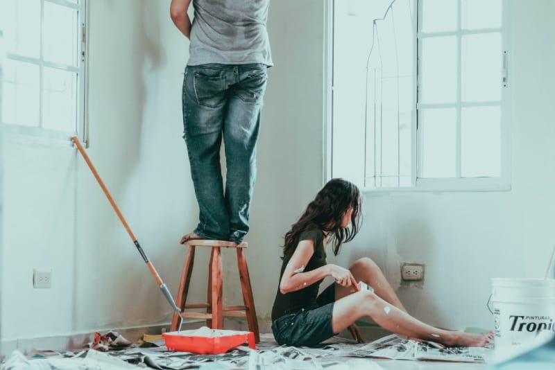 man and woman painting wall in their house