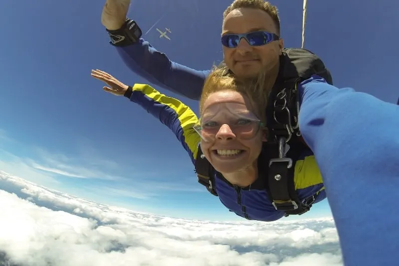 man with blue sunglasses and woman skydiving