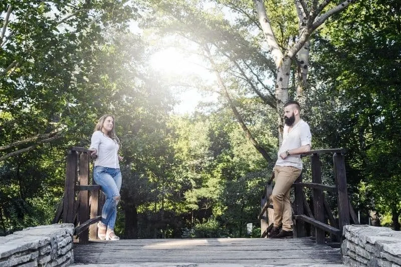 couple standing at wooden bridge looking at each other on thier first meeting