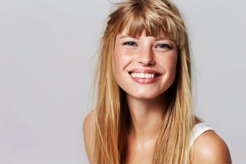 lovely young woman with blonde hair smiling in the studio