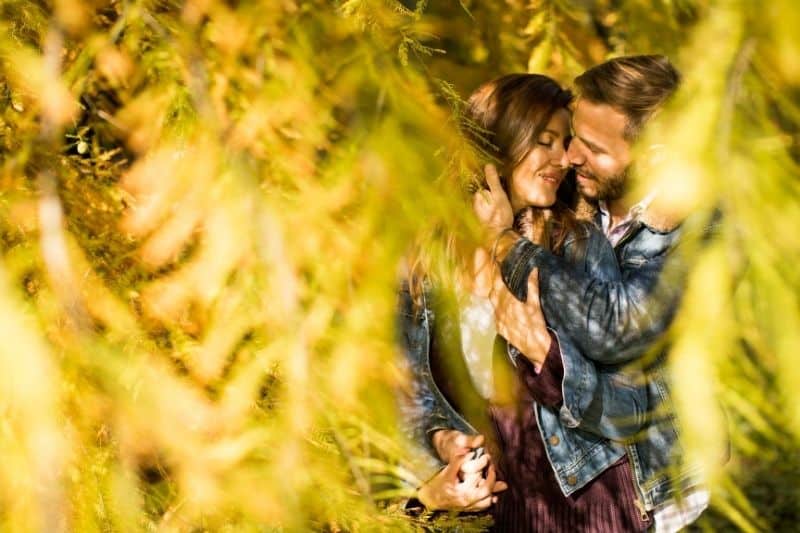 pareja de enamorados abrazándose en el parque de otoño