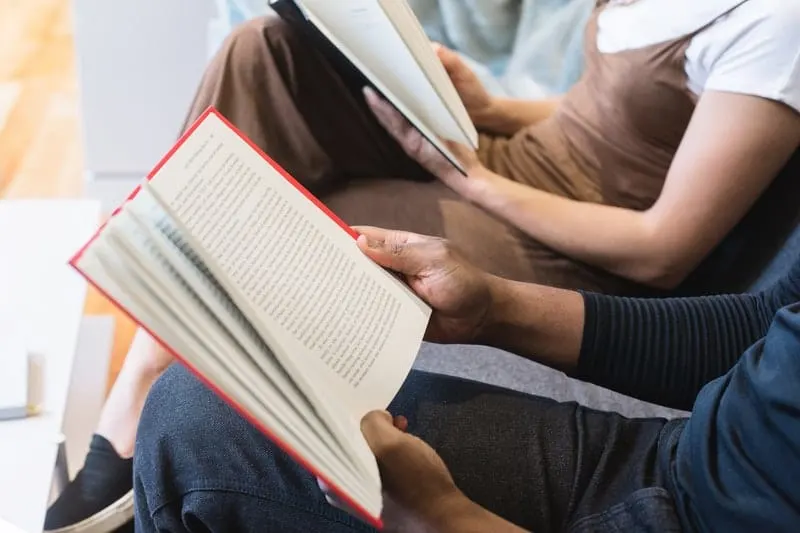 man and woman reading books sitting next to each other