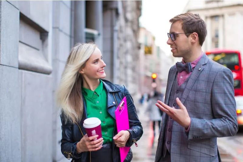 man and woman talking in the street woman bring coffee