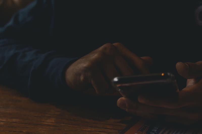 man using phone while sitting at table