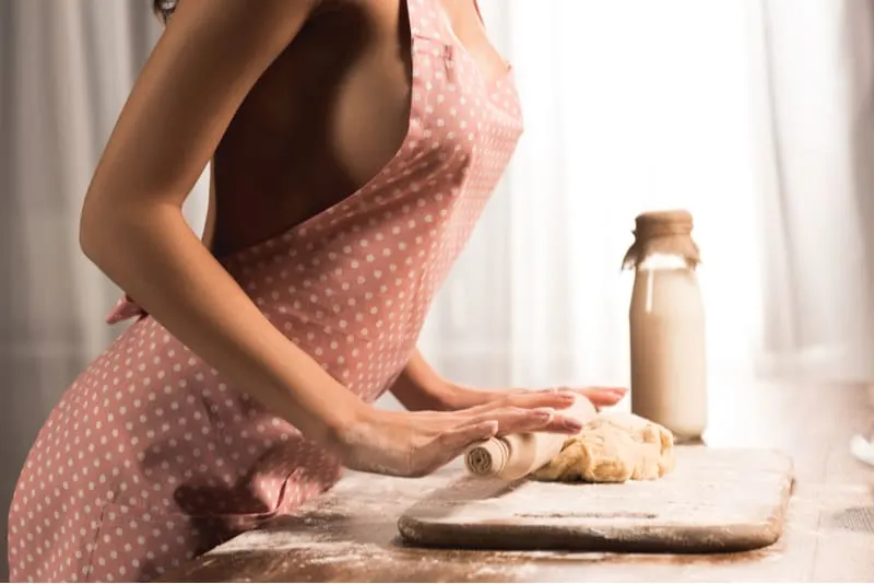 partial sideview of sexy woman baking and rolling pin into flour