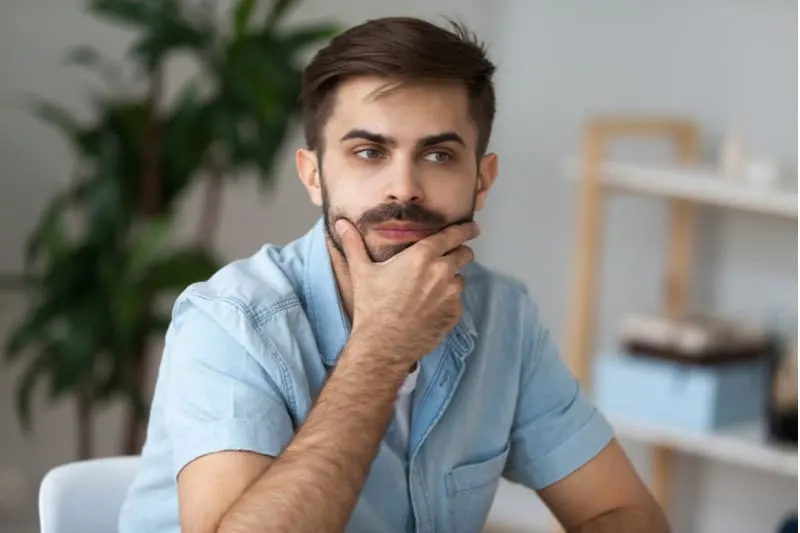 pensive man with moustache sit on office