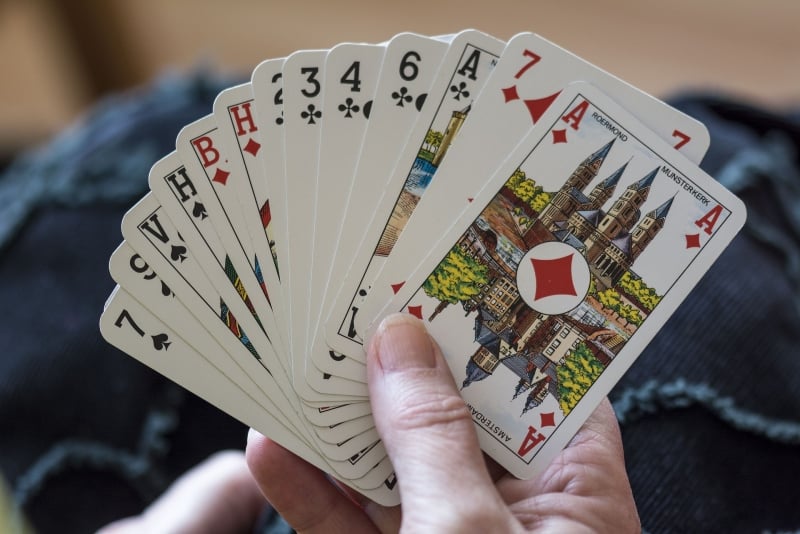 person holding cards while playing card game