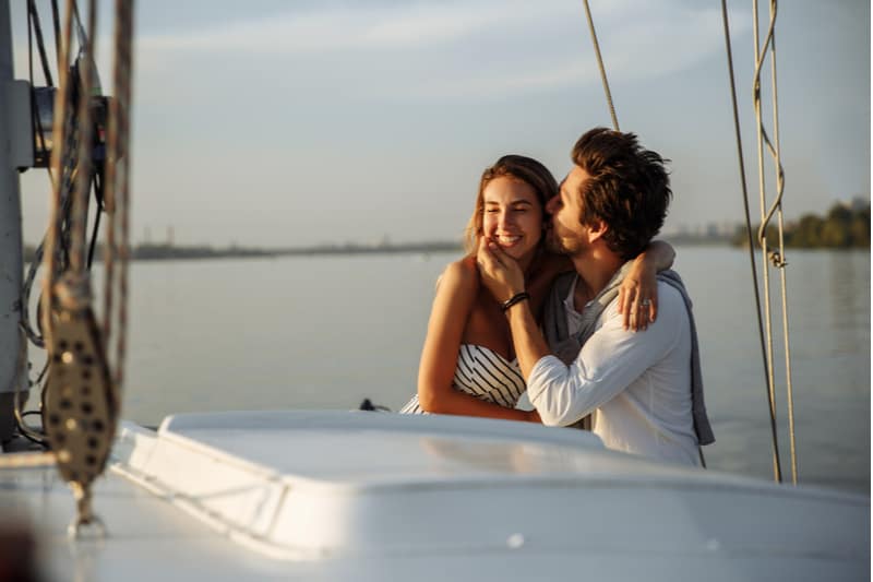 romantic couple on boat enjoying the day man kissing the woman