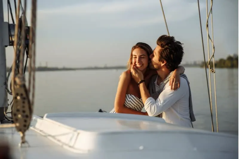 romantic couple on boat enjoying the day man kissing the woman