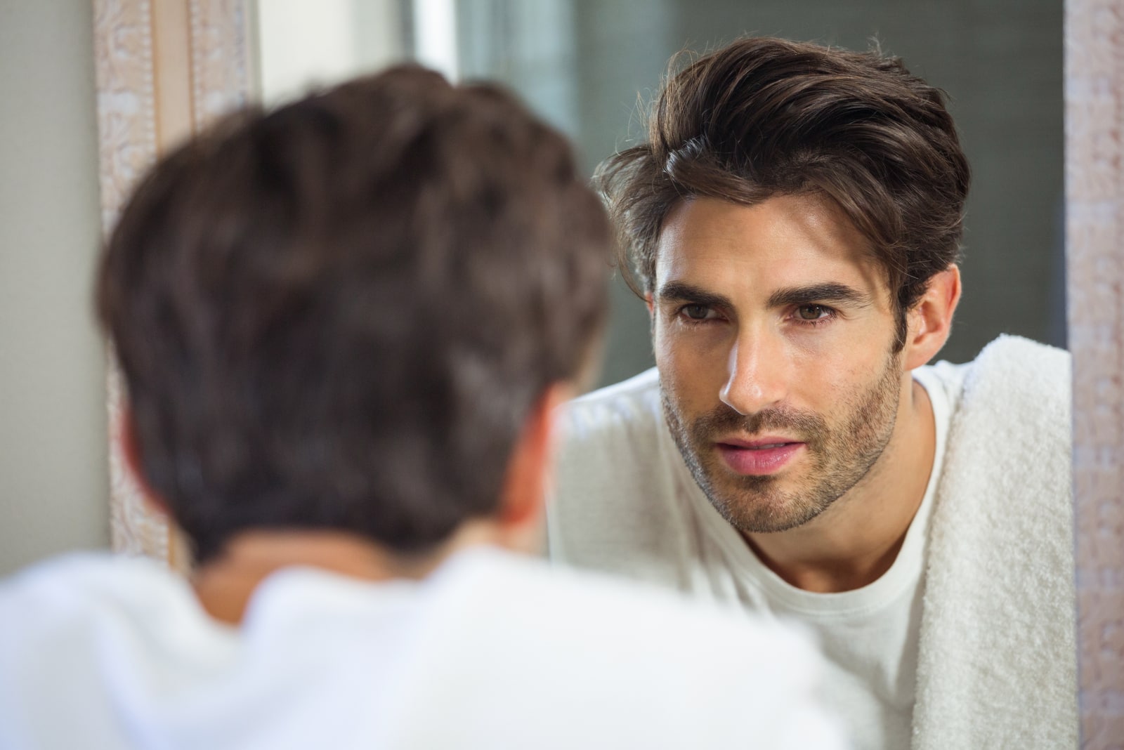 serious man looking at mirror