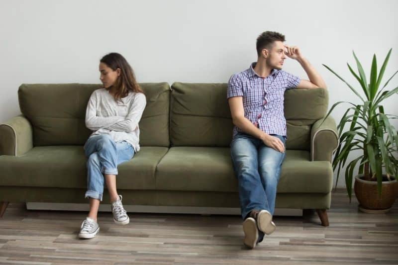 pareja en silencio después de una pelea sentado en el sofá dentro de la sala de estar