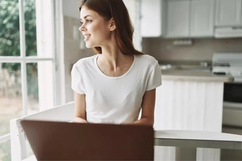 smiling woman working at home wearing white shirt