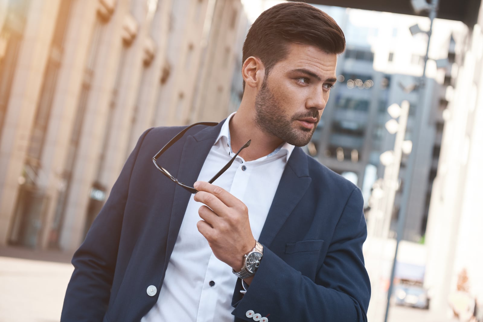 stylish man holding sunglasses