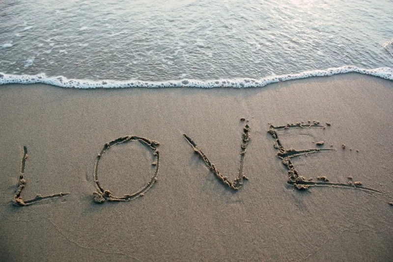 love text on seashore near sea