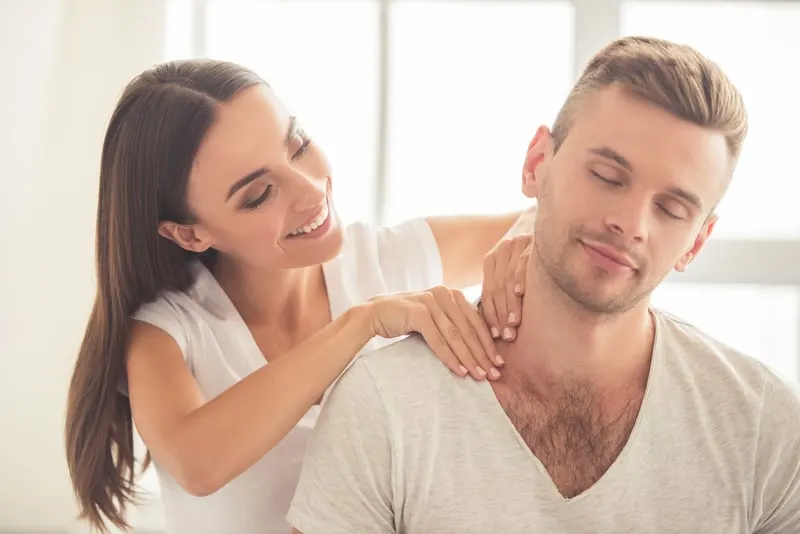 woman giving a massage on a man's shoulder while sitting
