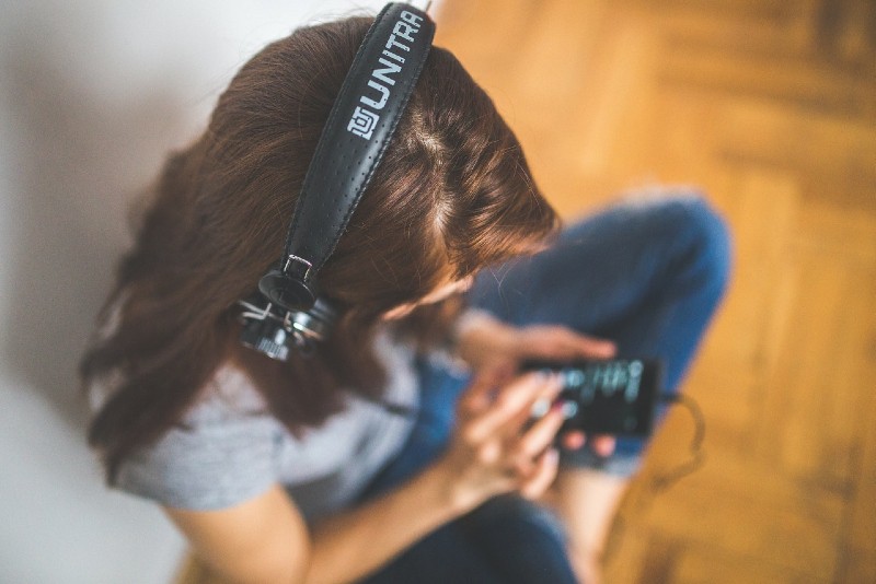 woman listening to music while sitting on floor
