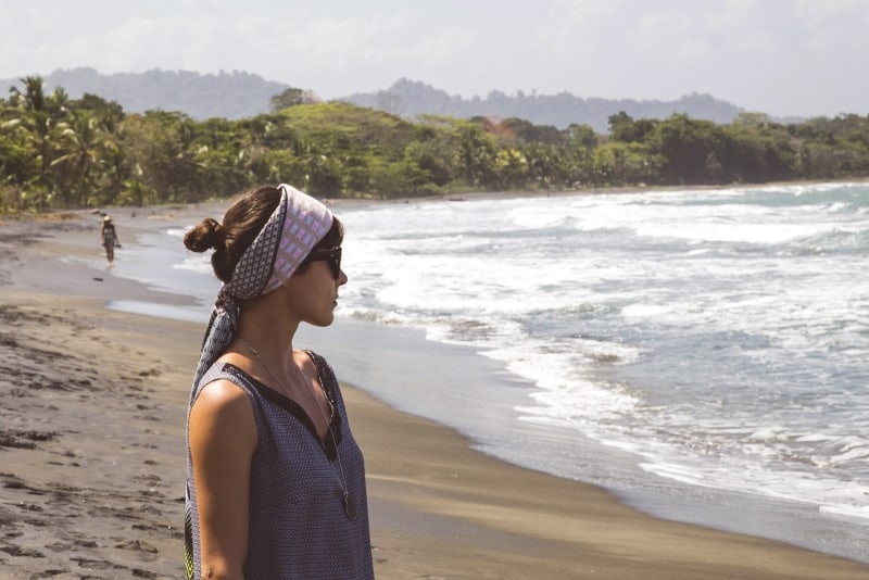 donna con foulard che guarda l'oceano