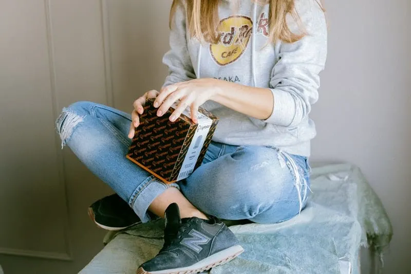 woman opening a box while sitting on a table
