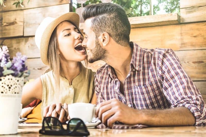 woman playing with man while having coffee inside a cafe