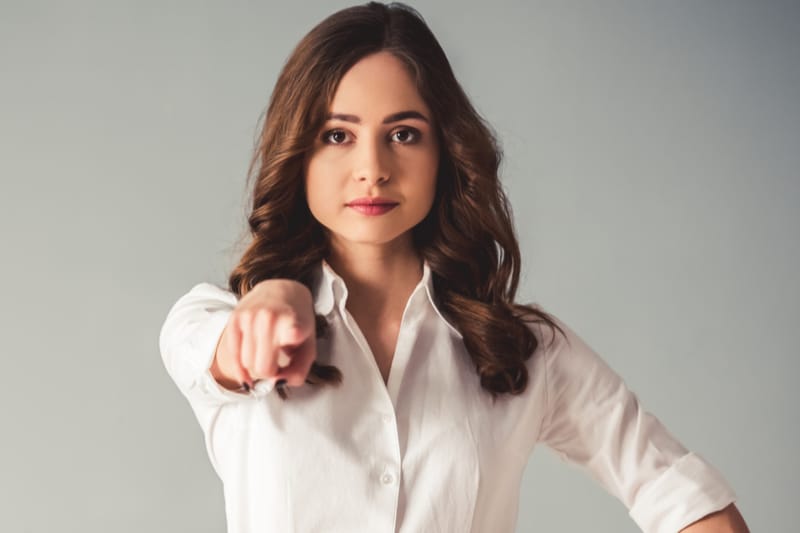 woman pointing finger at the camera wearing business wear
