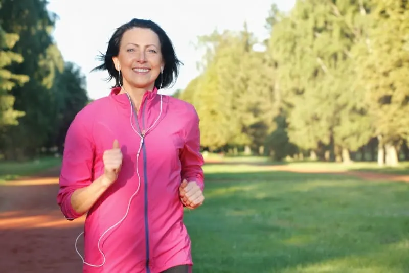 woman with headphones running in park