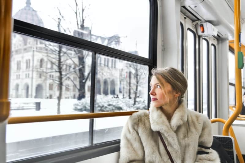 woman sitting in public transport looking through window