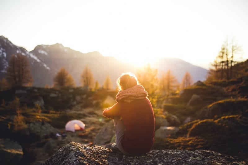 woman sitting on rock during golden hour