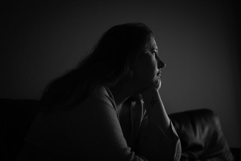 woman sitting on sofa with her head on her hand