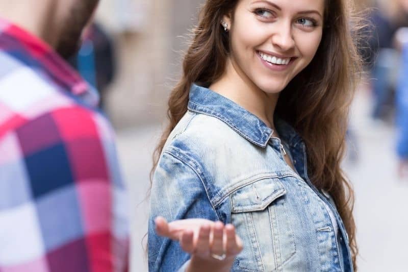 woman smiling back at a strange standing along the street
