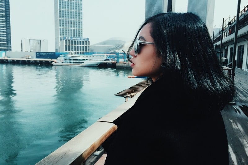 woman with sunglasses standing near water