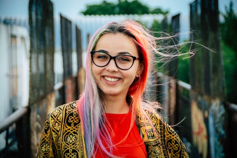 mujer con gafas de pie sobre un puente