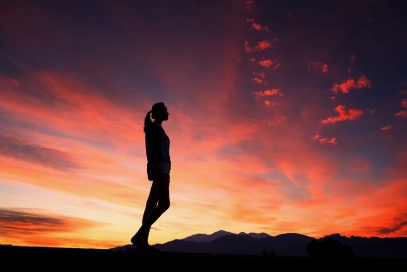 mujer de pie al aire libre durante la puesta de sol