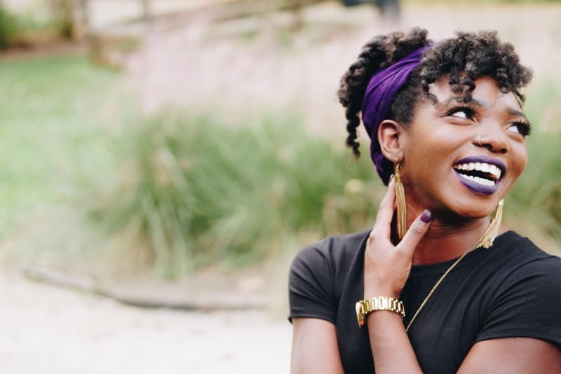 smiling woman with golden watch standing outdoor