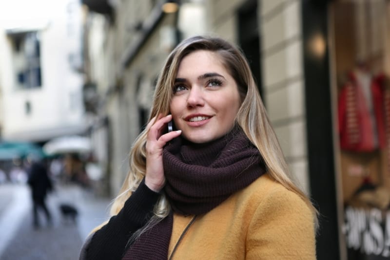 blonde woman with brown scarf talking on the phone