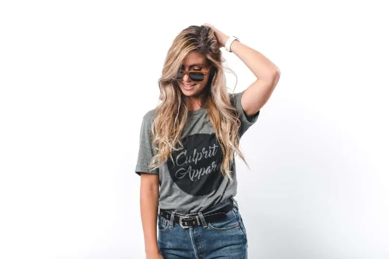 blonde woman with sunglasses touching her hair