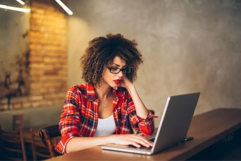 woman working at laptop indoors wearing eyeglasses