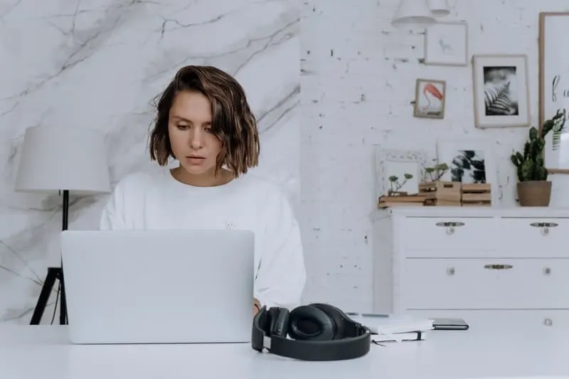 woman working at the office with laptop and earphones on the table