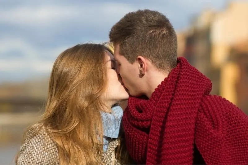 young couple kissing on cold days outdoors